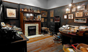 Installation photograph of the Henry Darger Room, its fireplace and table with paint materials