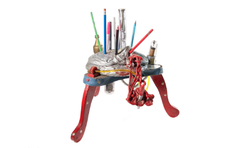 Photograph of a pencil holder sculpture with various colored pencils and other objects stuck inside