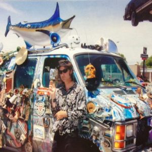 Photograph of Bob Buchholz standing in front of a decorated van
