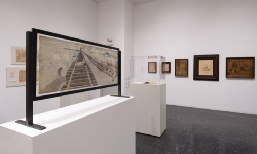 Photographs of works of art, including paintings and tracings, by Henry Darger on exhibition